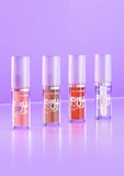 Four lip plumper bottles from L.A. Colors on a purple background